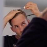 mann-traegt-harvekst-hair-serum-mit-pipette-auf-den-haaransatz-auf-im-badezimmer